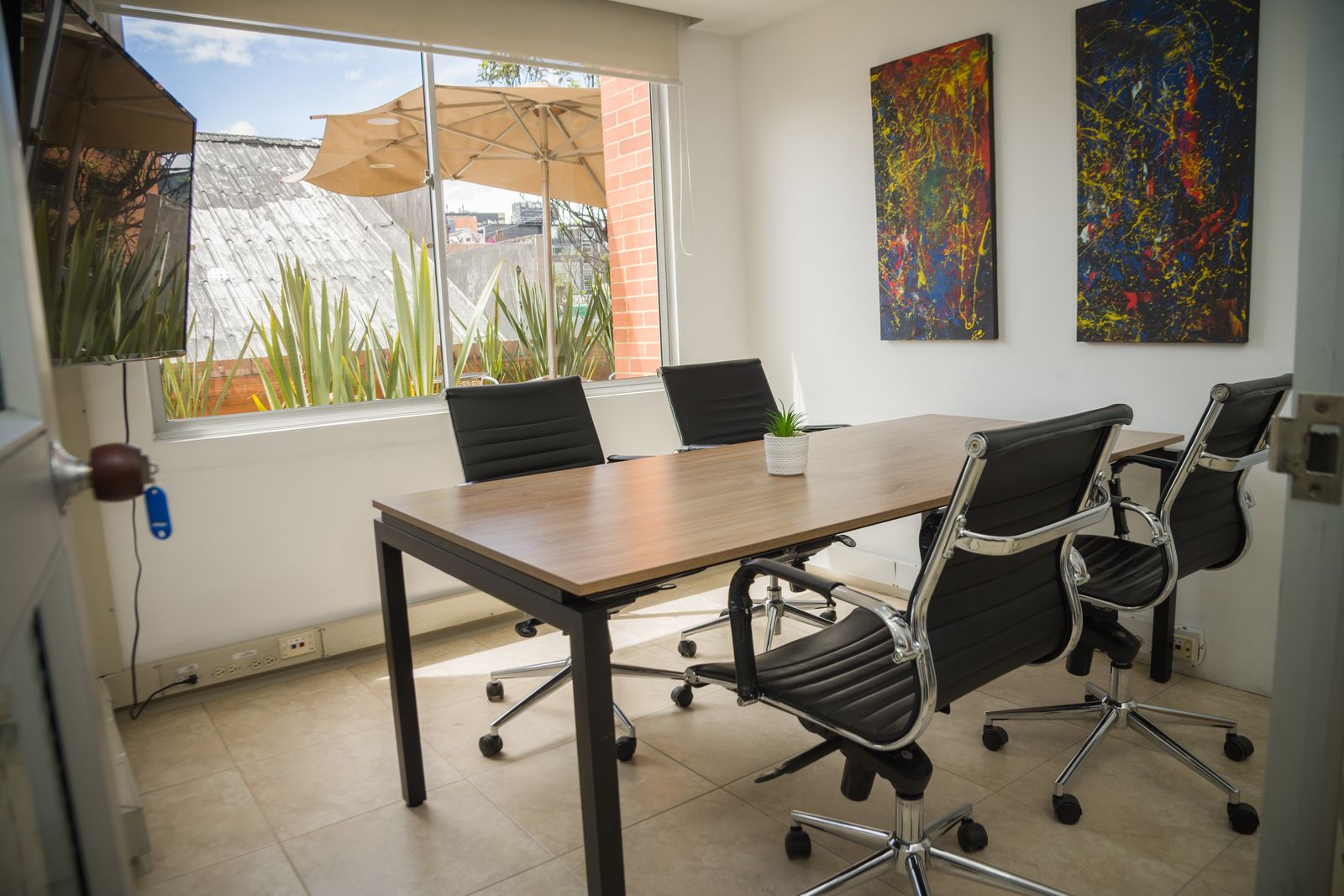 Sala S con mesa de madera, cuatro sillas y ventana